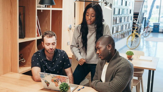 Small team working together around a laptop in a modern office