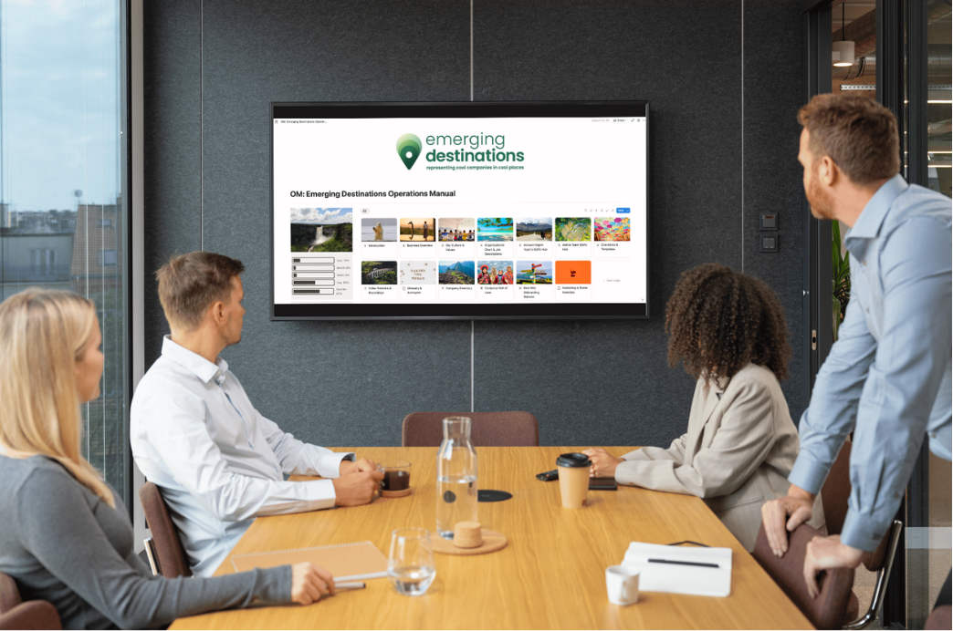Team reviewing a client's operations manual on a screen during an on-site working session
